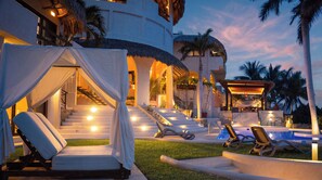 Un resort con piscina, sillas de descanso y una escalera que conduce a las plantas superiores.
