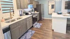Una cocina moderna con electrodomésticos de acero inoxidable, armarios de madera y una isla central.