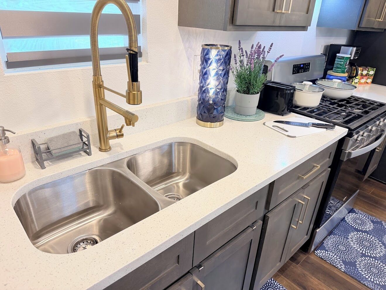 A kitchen with a double sink, stainless steel faucet, and modern appliances.