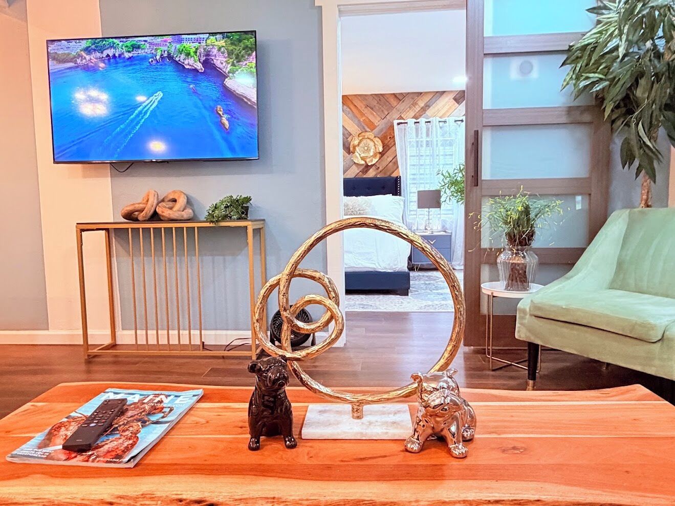 Una sala de estar con televisor de pantalla plana, un adorno decorativo y una revista sobre la mesa de centro.