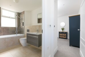 Ein modernes Badezimmer mit Badewanne, Toilette und Waschtisch.
