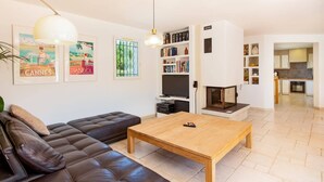 Ein Wohnzimmer mit Sofa, Couchtisch, Kamin und Bücherregal.