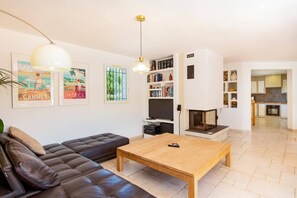 Ein Wohnzimmer mit Sofa, Couchtisch, Kamin und Bücherregal.
