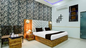 A bedroom with a bed, bedside table, lamp, and a chair.