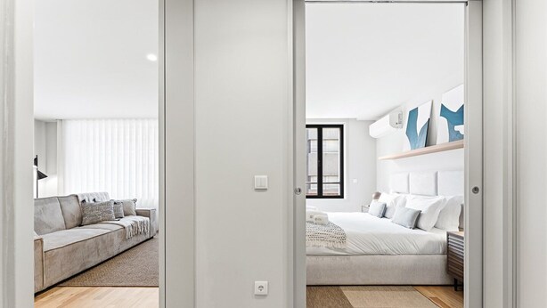 Une chambre à coucher moderne avec un lit, une table de chevet et une fenêtre.