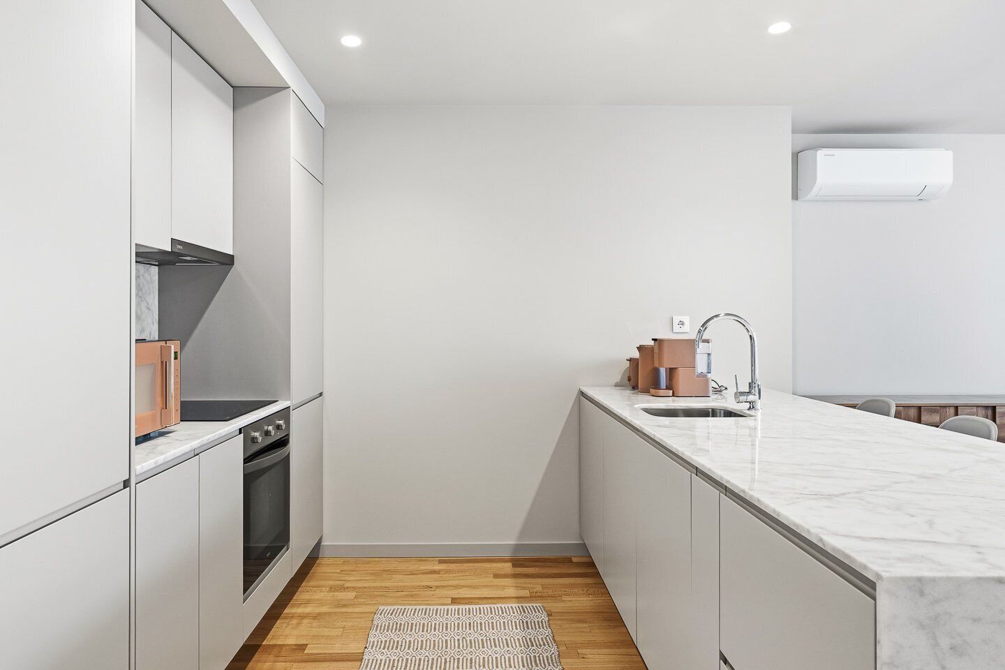 A modern kitchen with a built-in oven, microwave, and sink.