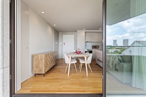 Eine moderne Wohnung mit Essbereich, Küchenzeile und Blick auf die Stadt.