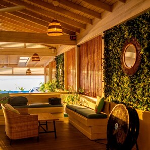 A room with a wooden ceiling, a sofa, a table, and a fan. - Sunfish 1-bedroom ocean view apartment in Sand Street, Speightstown Apt 2 (Speightstown)