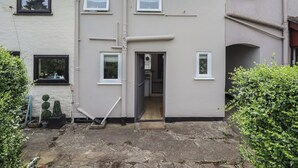 A residential building with multiple windows, a visible door, and a chimney. - Pax Cottage (Beccles)