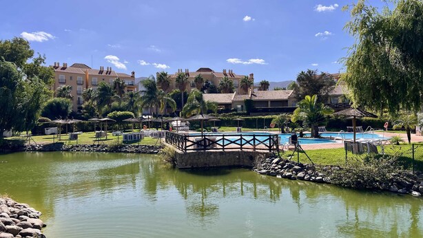 A resort with a swimming pool, a bridge, and a pond. - Relax Oasis and Terrace in Sol Andalusi (Alhaurín de la Torre)
