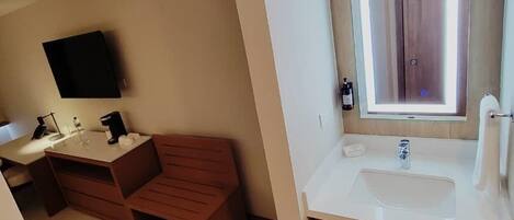 A modern bathroom with a vanity, sink, and mirror.