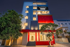 A multi-story building with a sign reading 'TOWNHOUSE' and 'OYO-Serviced'.