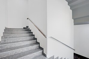 A staircase with a handrail and a wall-mounted light fixture.