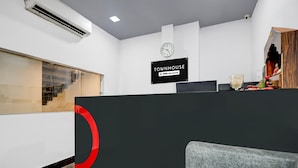 Ett receptionsområde med en skylt där det står ”TOWNHOUSE” och ”OYO-Serviced”.