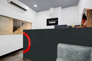 Ein Empfangsbereich mit einem Schild, auf dem 'TOWNHOUSE' und 'OYO-Serviced' steht.