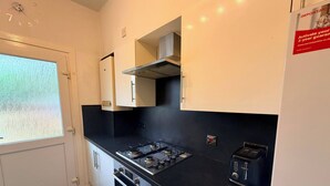 Cucina con piano cottura a gas, forno e tostapane.