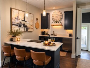 A modern kitchen with a central island, bar stools, pendant lighting, and a large wall clock. - NEW Lake Norman Loft | Pickleball Pool/Spa | Dock (Denver)
