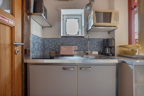 A kitchen with a sink, a toaster, a kettle, and a microwave. - Apartment 'Fewo Badehus' with Shared Terrace, Shared Garden and Wi-Fi (Röbel)