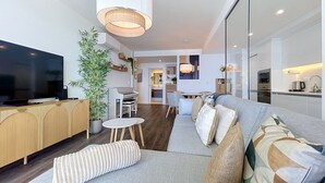A modern living room with a sofa, a TV, a piano, and a dining area. - Azure Atlantic Horizon by Atlantic Holiday (Camara de Lobos)