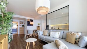 A modern living room with a sofa, a small round table, and a large mirror. - Azure Atlantic Horizon by Atlantic Holiday (Camara de Lobos)