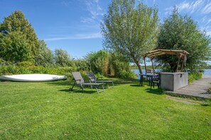 A grassy outdoor area with a pool, lounge chairs, a table, and a pergola. - Apartment 'Fewo Möwe' with Shared Terrace, Shared Garden and Wi-Fi (Röbel)