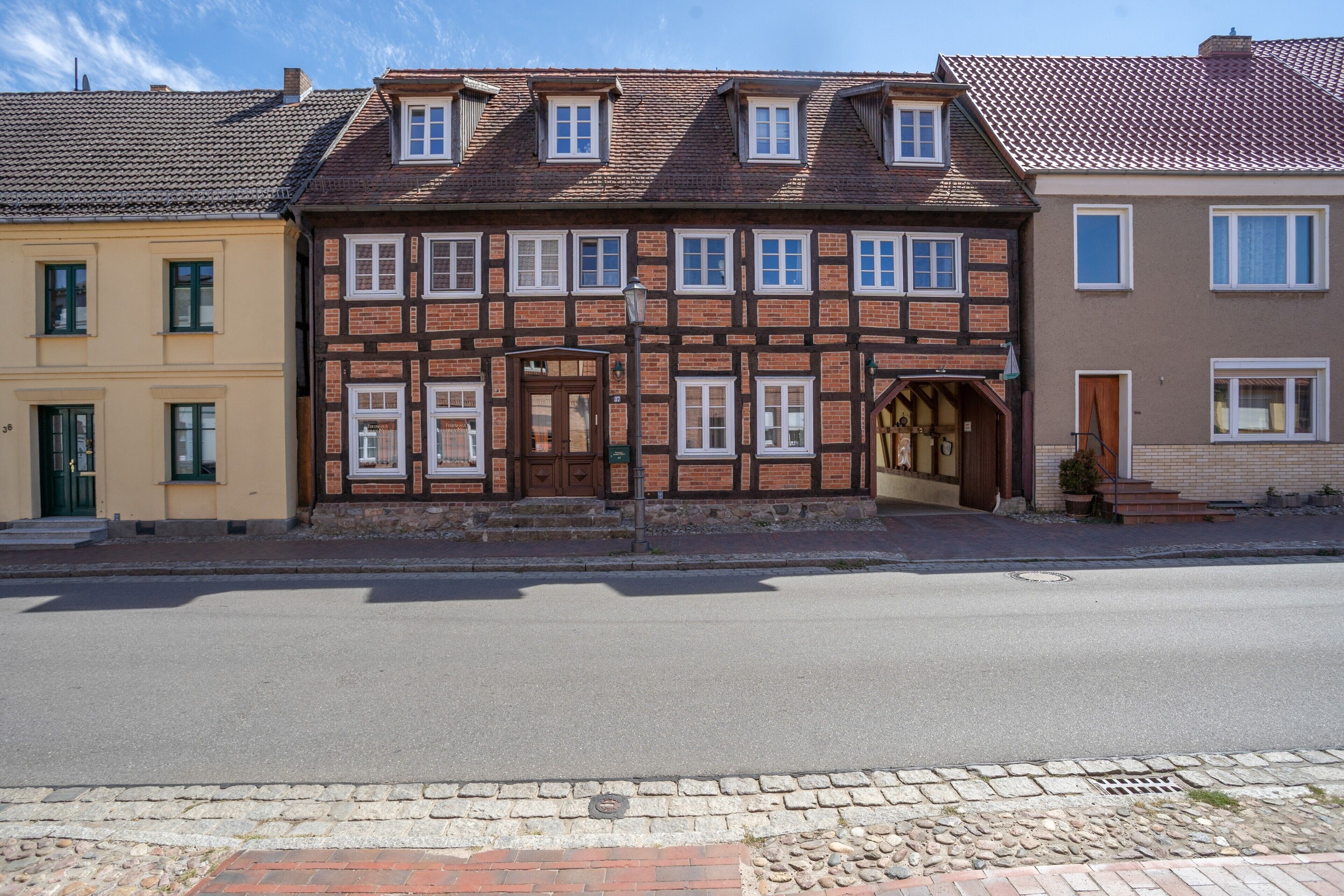 Une rangée de maisons traditionnelles à colombages, avec une rue devant.