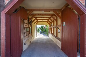 A corridor with wooden beams and red doors, leading to a covered outdoor area. - Apartment 'Schwalbe' with Shared Terrace, Shared Garden and Wi-Fi (Röbel)