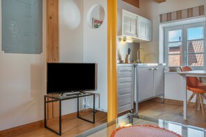 Una cuina moderna amb armaris blancs, forn integrat i finestra amb vista exterior.