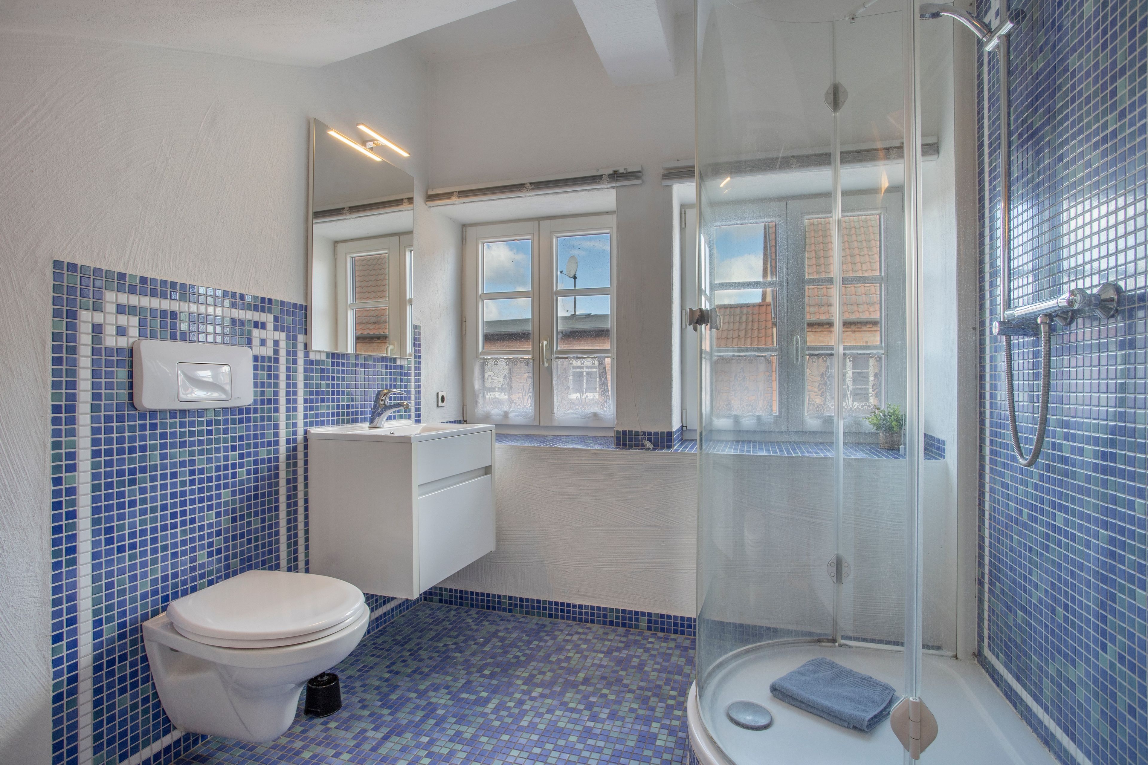 Ein Badezimmer mit Toilette, Waschbecken und Duschbereich.