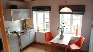 A compact kitchen with a dining area, a window with a view, and a potted plant on the table. - Apartment 'Fewo Schwan' with Shared Terrace, Shared Garden and Wi-Fi (Röbel)