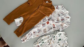 Une table ronde recouverte d’une nappe marron, avec des chaises blanches à motifs.