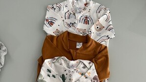 Une tenue de bébé est disposée sur une surface plane.