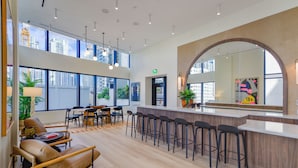 Un interior moderno con una zona de bar, asientos y ventanas amplias.