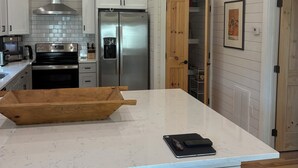 A kitchen with a central island, stainless steel appliances, and a pendant light. - Awesome 3-bedroom house with AC in charming Burnsville (Burnsville)