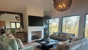 A living room with a fireplace, sofas, a coffee table, and a TV. - Awesome 3-bedroom house with AC in charming Burnsville (Burnsville)