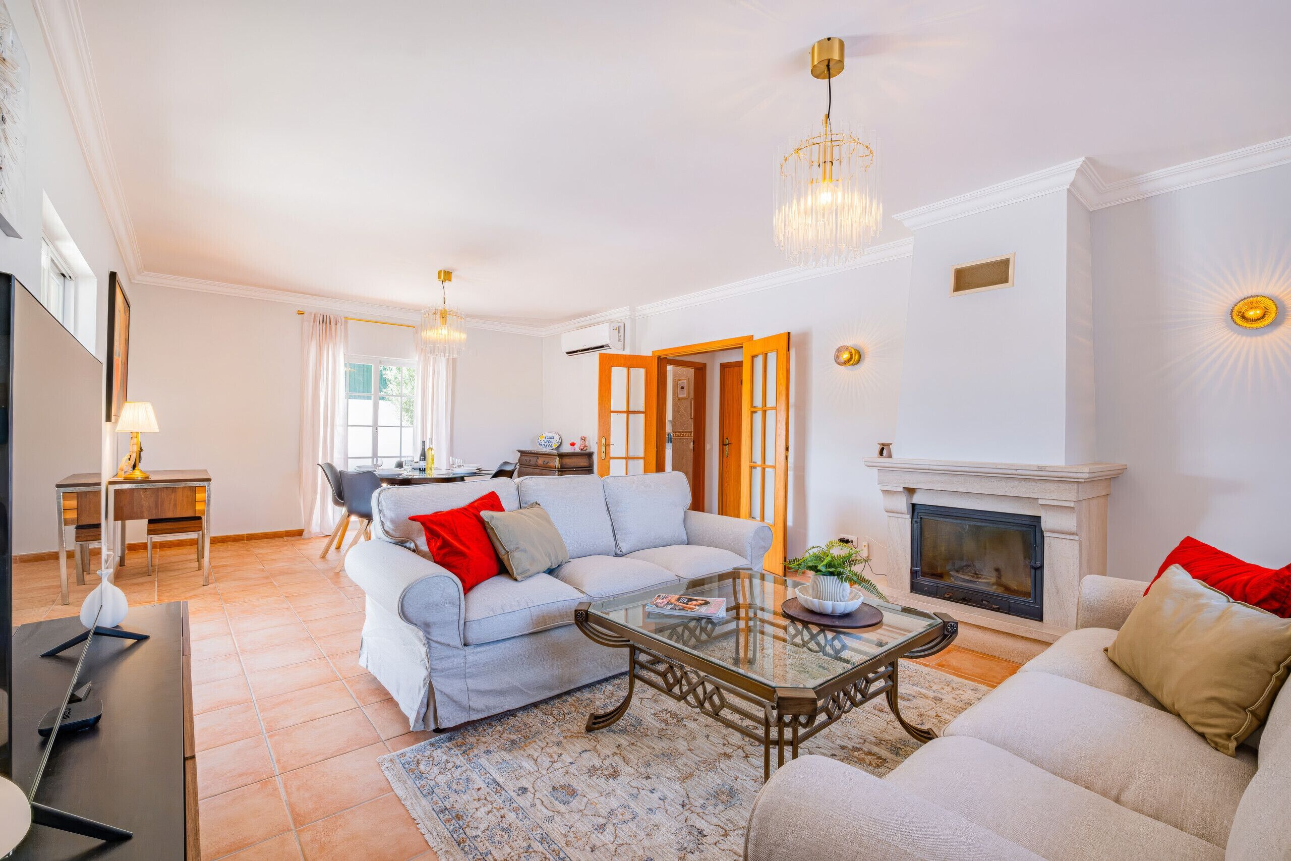 Una sala de estar con sofá, mesa de centro, chimenea y comedor con mesa y sillas.