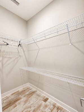 A laundry room with metal drying racks and a wooden floor. - Stay Anchored at 30a (Watersound)
