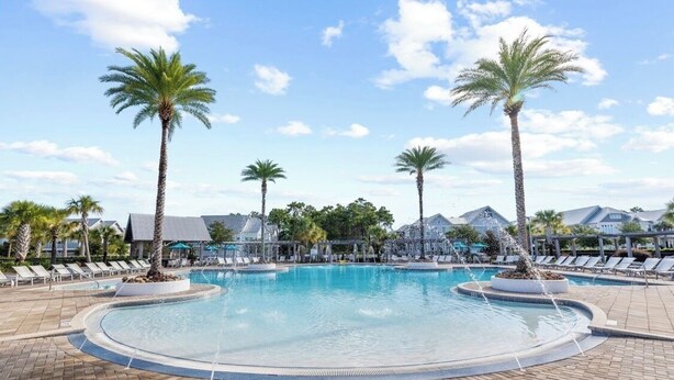 A pool area with lounge chairs and palm trees. - Stay Anchored at 30a (Watersound)