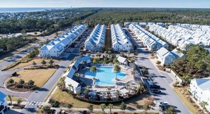 A resort with multiple white buildings, a central swimming pool, and a well-maintained landscape. - Stay Anchored at 30a (Watersound)