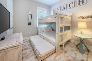 A bunk bed room with a desk, a lamp, and a wall with the word 'BEACH' spelled out. - Stay Anchored at 30a (Watersound)