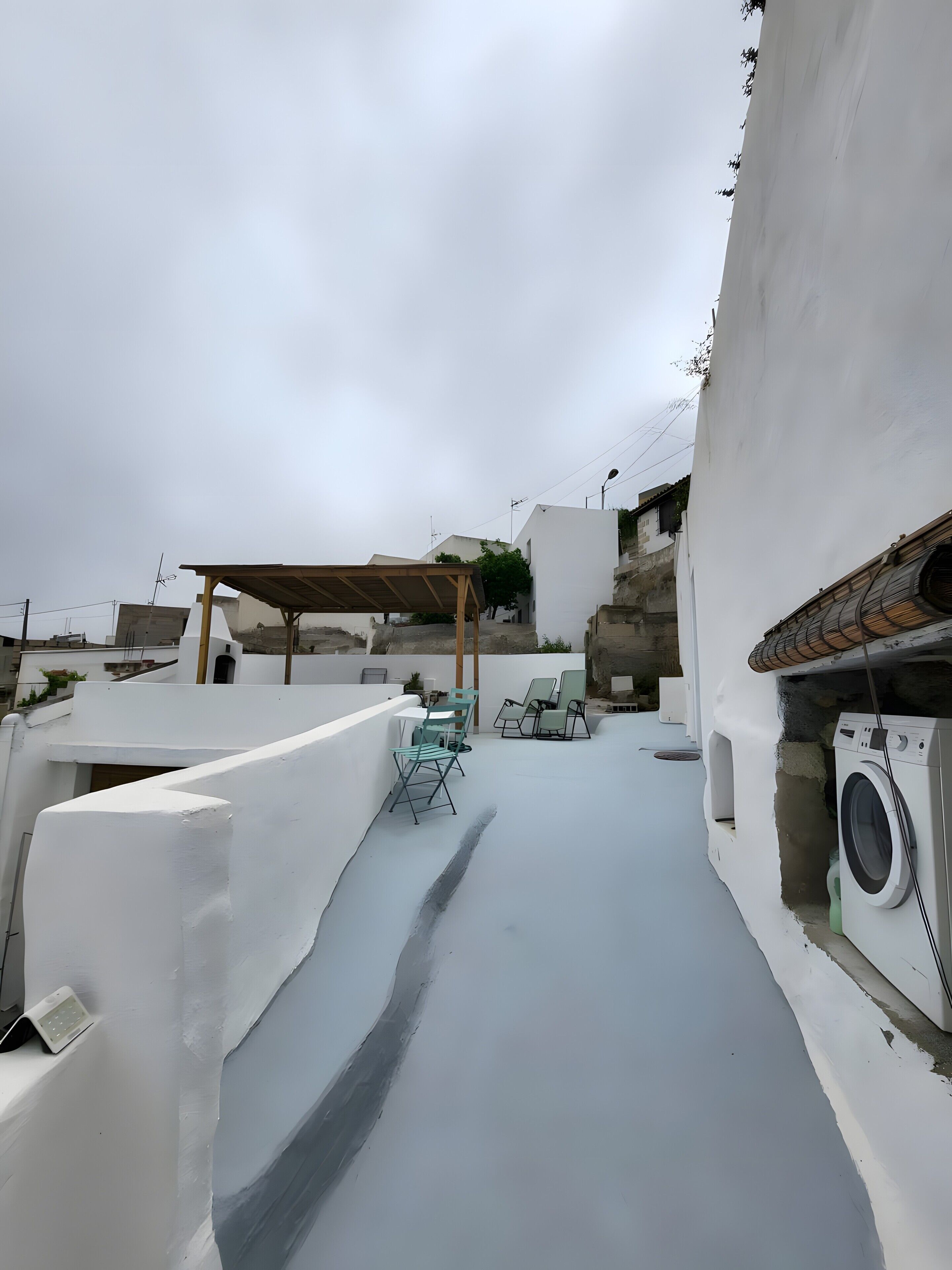 Une terrasse sur le toit avec une pergola, des sièges d’extérieur et un lave-linge.