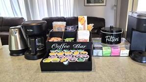 Un espace café aménagé avec différents types de dosettes de café, une machine à café et un appareil Keurig.