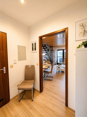 A modern interior with a wooden floor, a dining area with a table and chairs, and a staircase leading to another level. - "Waldblick" Vacation Rental with a Balcony and Rooftop Terrace Offering a Stunning South-Facing View - My SWH (Schonach im Schwarzwald)