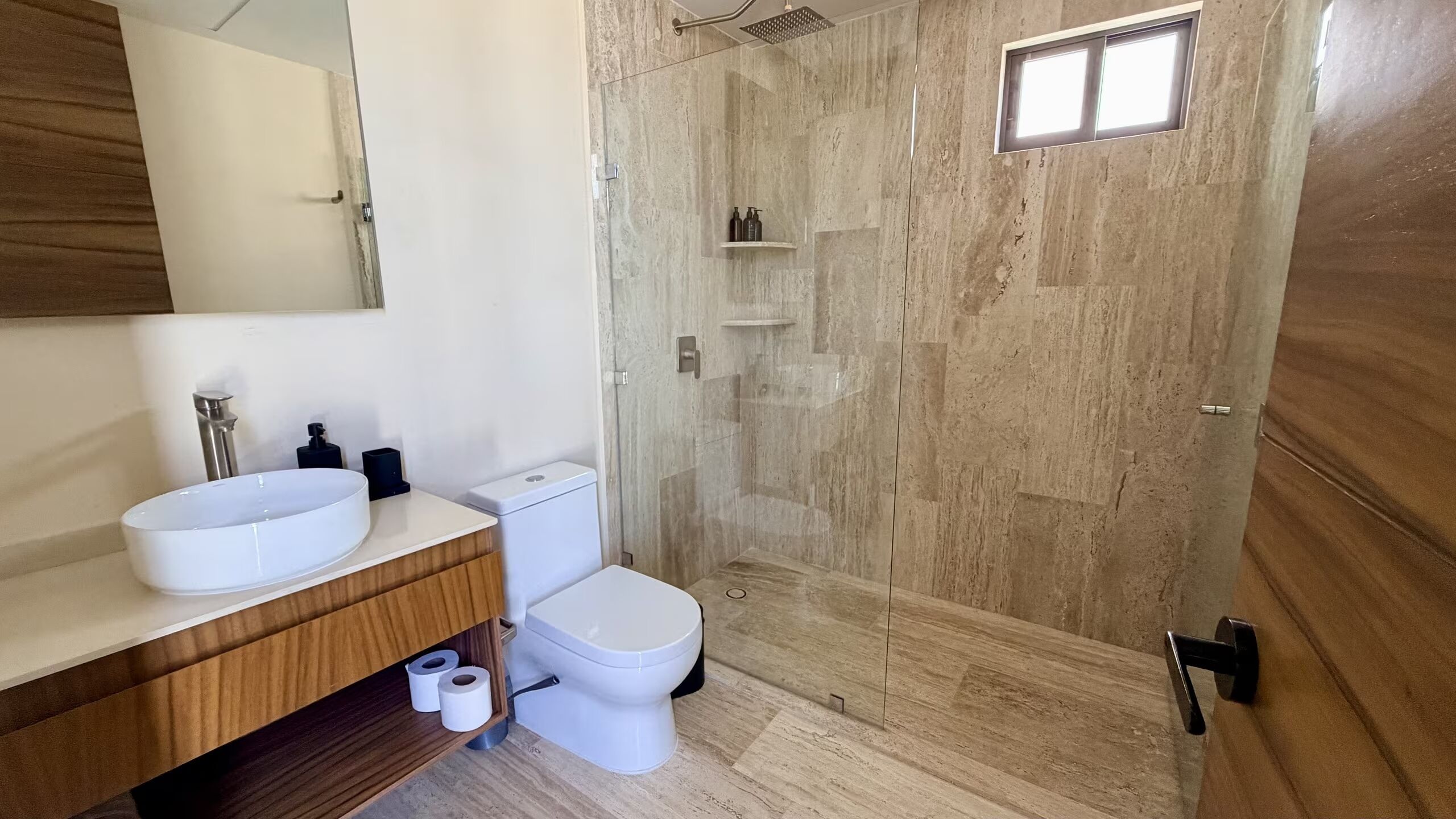 A bathroom with a white sink, toilet, and shower.