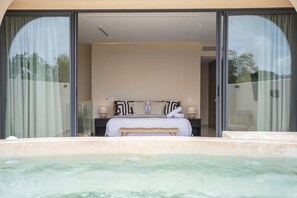 A bedroom with a large bed, a bench, and a hot tub in the foreground. - Exclusive Villa: Stunning Rooftop Pool, Jungle Views, and Beach Concierge (Tulum)
