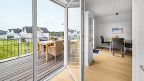 Un appartement moderne doté d’un balcon, d’un coin repas et d’une cuisine.