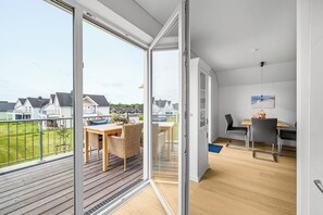 A modern apartment with a balcony, a dining area, and a kitchen. - Seeschwalbe - Balcony, parking space, wash-dryer, 3 TVs, infrared cabin (Olpenitz)