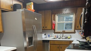 Une cuisine avec des meubles en bois, un réfrigérateur en acier inoxydable, un lave-vaisselle et une cuisinière.