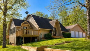 Une maison à deux étages avec un balcon, un garage et une pelouse bien entretenue.