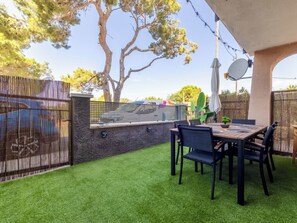 Eine Terrasse mit Tisch und Stühlen, eine Steinsäule und ein Zaun.